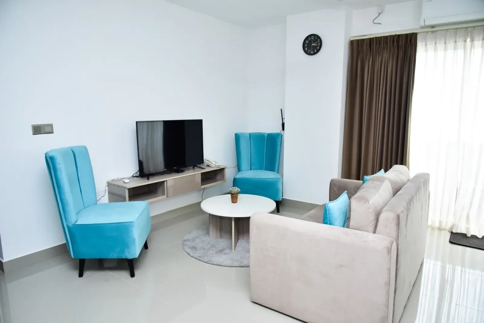 Living room with blue armchairs and a TV