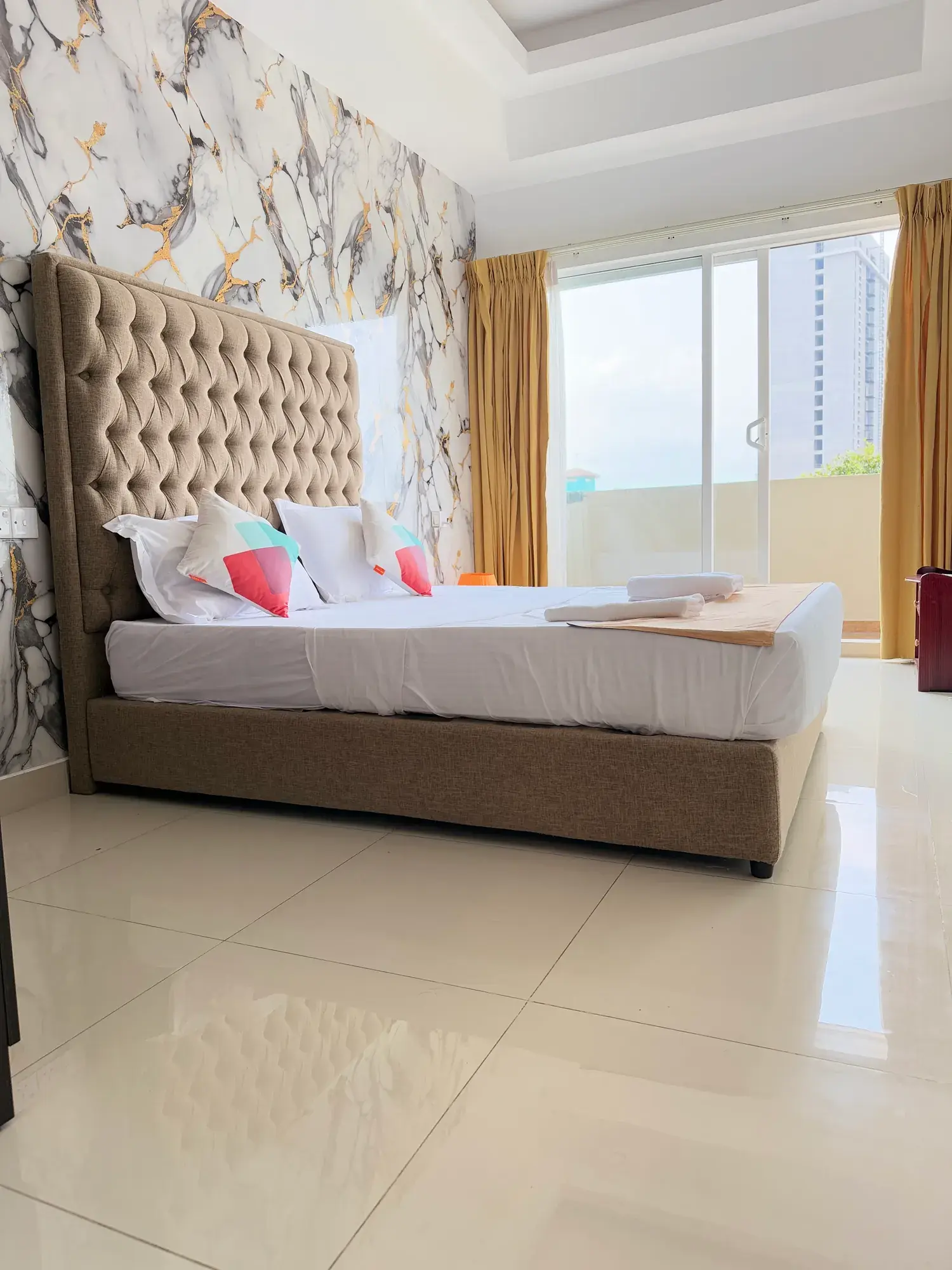 Bedroom with a tall headboard and a window